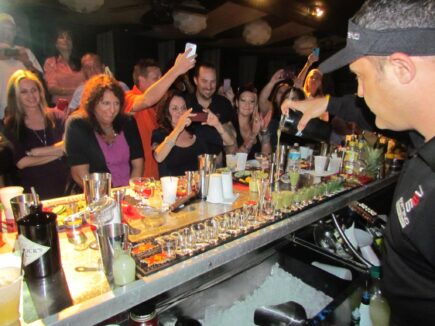 Participants in a cocktail making class in Hollywood, Fl taking pictures with instructor Isaac Ergas after he demonstrated a cocktail creation.