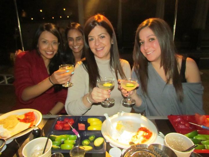 A lively birthday cocktail-making class in Hollywood, Florida, featuring a bride-to-be and her friends. The room is filled with laughter and excitement as they learn to craft various cocktails, sharing tips and enjoying each other's company in a festive atmosphere.