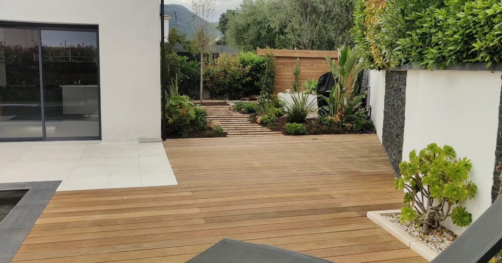 Découvrez un jardin contemporain alliant bois, carrelage blanc et verdure luxuriante.