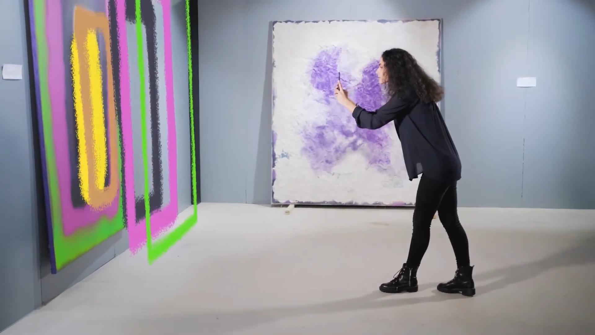 Visitatori che utilizzano l'app di realtà aumentata HistoriaVIVA per esplorare opere d'arte e reperti storici in modo interattivo.