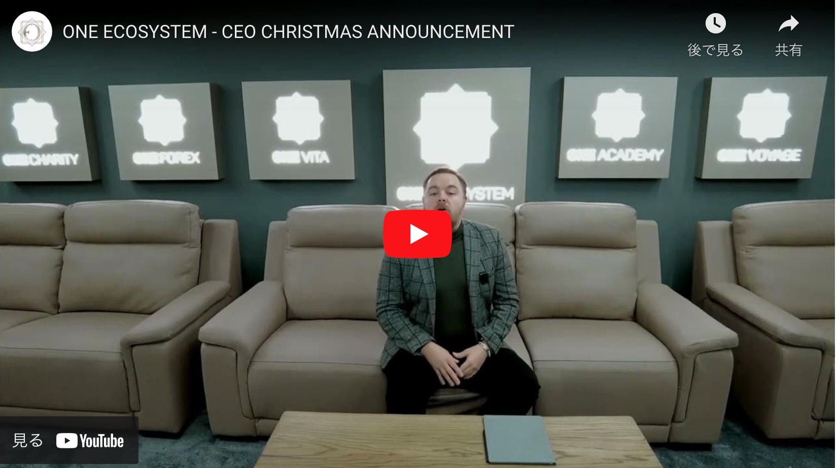 一個人坐在沙發上，前面是一面牆，牆上貼著 ONE ECOSYSTEM 每個部門的標誌，為 CEO 的節日公告做準備。