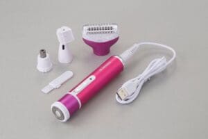 Pink and white electric shaver on white surface.
