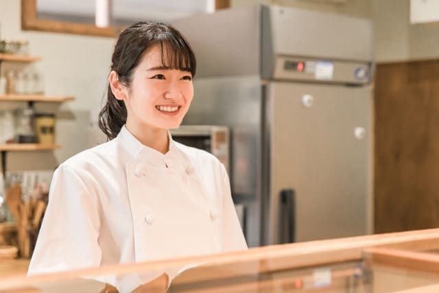 Young woman smiling in front of restaurant counter.