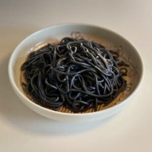 5 pieces of Kumiko brown rice daikoku noodles (okara, brown rice, hijiki & kelp, bamboo charcoal) (trial pack) are placed on the table.