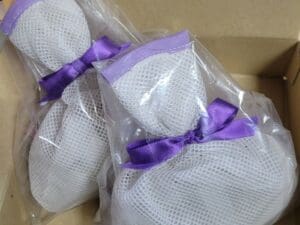 2 sacos de malha com fita roxa e 2 peças × 230g de cerâmica antibacteriana Clean U Super Ribbon para banho. Cerâmica + turmalina (prata, zinco, cobre, zeólita de magnésio, etc.) são colocadas na caixa.