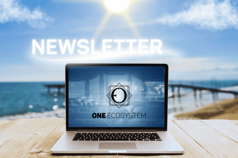 木製のテーブルの上にノートパソコンがあり、画面には「ONE ECOSYSTEM」と表示されています。その前にはビーチがあり、上空には「OESニュースレター」の文字が浮かび上がっています。