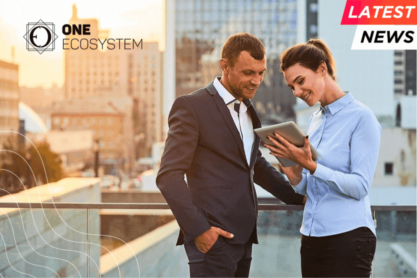 Two business professionals are standing on the rooftop, looking at their tablets together. In the background, you can see the cityscape at sunset. The text reads "One Ecosystem" and "Latest News."
