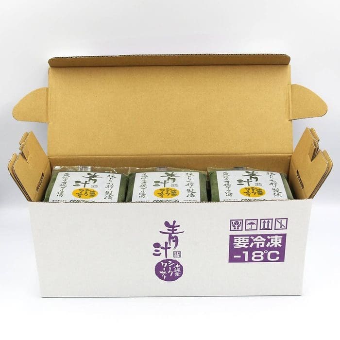 Inside the open cardboard box are three green green packages of green aojiru with Japanese characters written on them. The box states the storage requirements at -18°C.