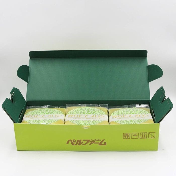 開けた緑色の箱の中には、緑と白の模様の個包装された商品が入っており、爽やかなメロンジュースと一緒に楽しむのにぴったりです。