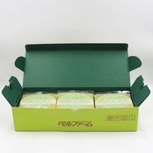 開けた緑色の箱の中には、緑と白の模様の個包装された商品が入っており、爽やかなメロンジュースと一緒に楽しむのにぴったりです。