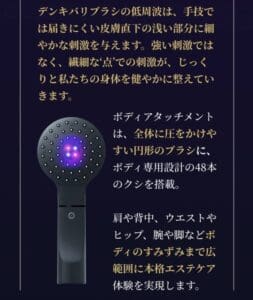 It is a black hand-held device with a circular head that features multiple small protrusions, with a purple light in the center. On the top and bottom of the device, there are Japanese notations such as "Denkibari Brush 2.0 + Body", indicating that it is an innovative tool recognized by the BODY AWARD 2022.
