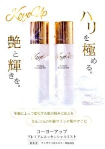 Imagem de dois frascos de KoyoUp Premium Essential Mist em pé sobre fundo branco com texto japonês anunciando os benefícios do soro hidratante para a pele.