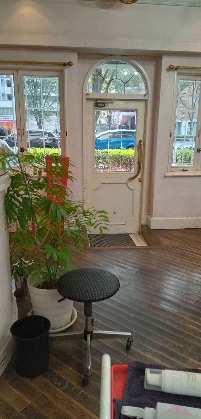 內部鋪有優雅的木地板和簡單的凳子，旁邊擺放著鬱鬱蔥蔥的盆栽，門向外打開。 這間極簡主義的客房將自然元素無縫融入日常生活，營造出寧靜祥和的氛圍。