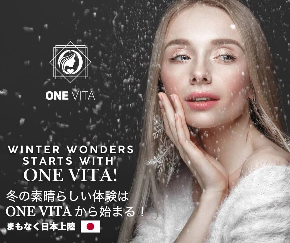 Cercada por flocos de neve caindo, uma mulher de cabelos compridos está sorrindo enquanto toca seu rosto. As palavras "A diversão do inverno começa com uma vitamina!" são escritas em inglês e japonês, enfatizando os cuidados com a pele com ingredientes de origem natural.