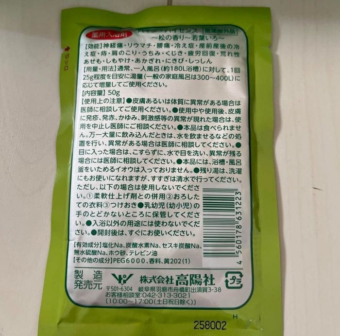 The back of the green food package with Japanese text displays nutritional information, the term "Pine Hisense," and a light-surface barcode that resembles the practical details found on medicinal bath salts and portioned products.