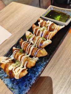 Pour the sauce over 4 fried dumplings and serve them on a rectangular plate with green onions and serve with dipping sauce.
