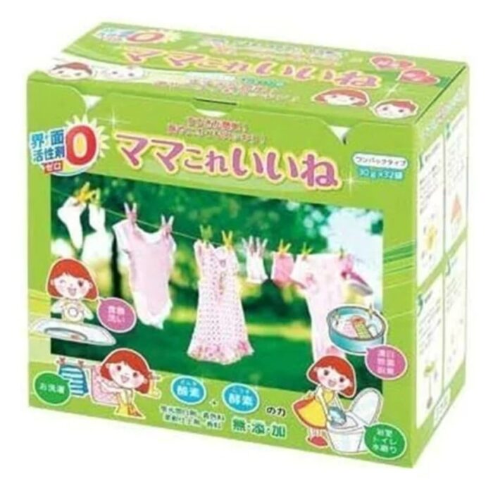 Una caja verde con una ilustración de una niña lavando la ropa y la leyenda "Mami, esto es bueno". La caja muestra ropa, lavadoras y detergentes colgando de ellas. El empaque tiene caracteres japoneses, enfatizando que es un tipo de paquete único con 32 bolsas.