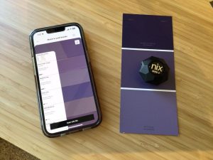 Sensor Nix Mini 3 junto a un smartphone mostrando coincidencias de colores en una aplicación móvil.